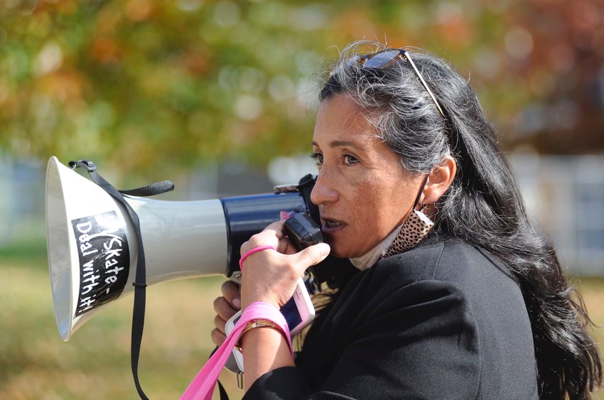 Activist in action. Sandra Cuellar-Oxford used a bullhorn to interrupt the press conference.