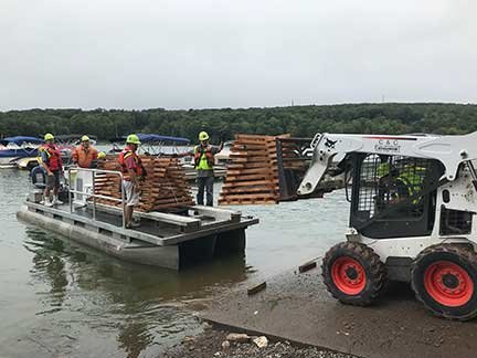 The finished structures are loaded onto a boat to be installed in the lake.