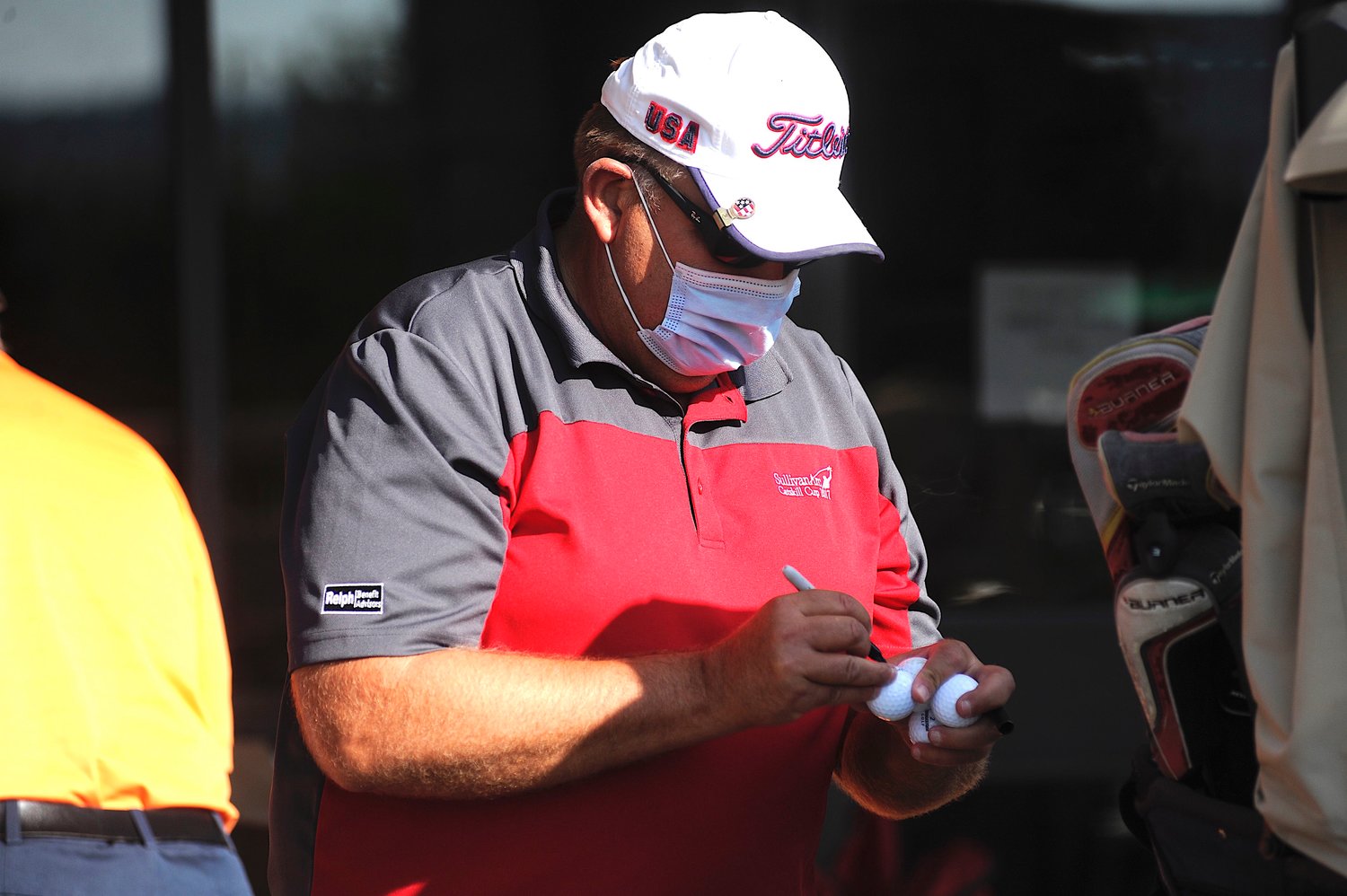 Last-minute details. Joe Burczak, on the team from Relph Benefit Advisors, initials his golf balls to keep track of them on the course.