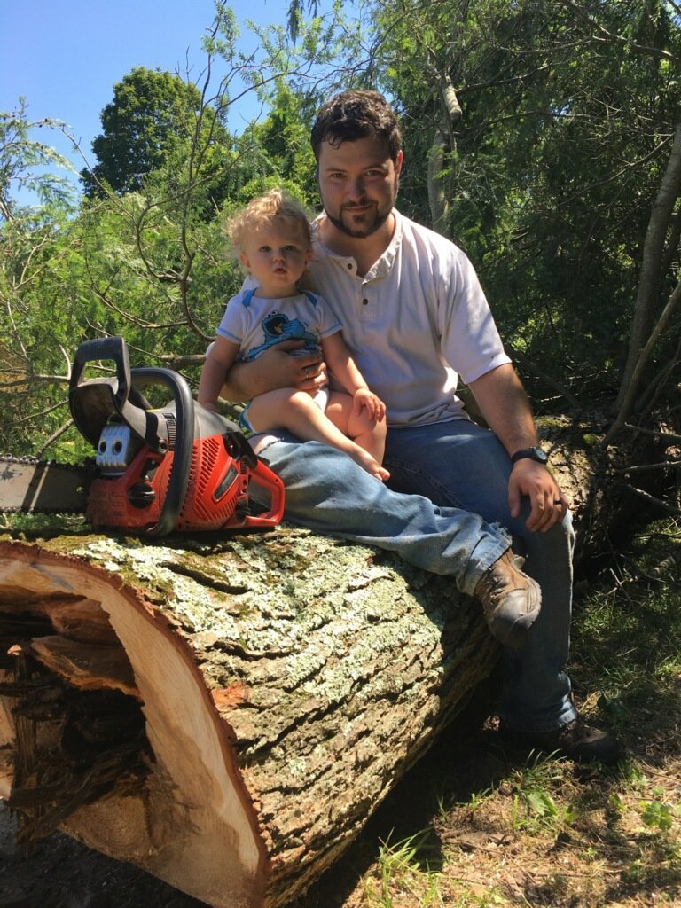 My son and I sit atop the freshly felled Hemlock in our yard.