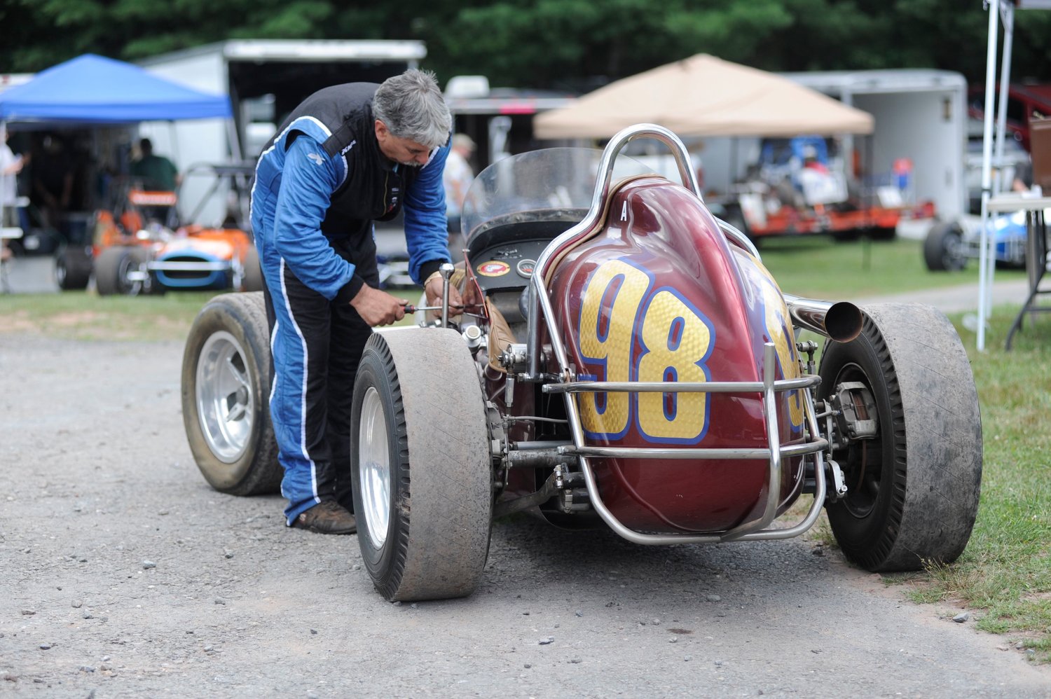 Last-minute adjustments. Keith Majka fine-tunes the carbs on his Offy-powered race car before taking to the asphalt.