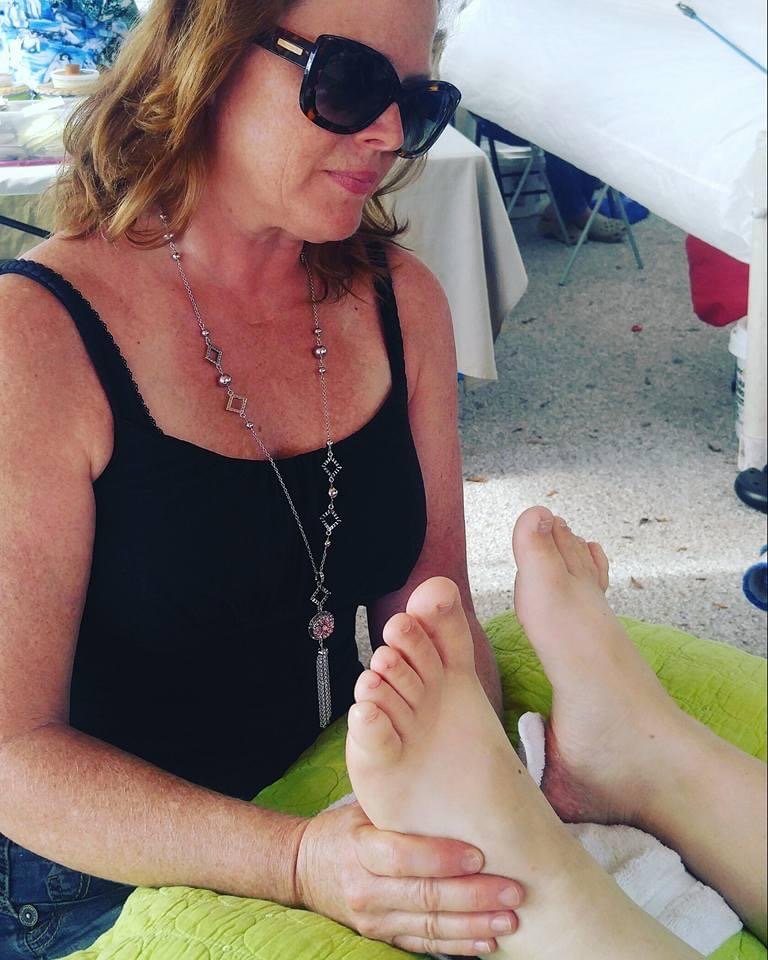 Reflexologist Caroline Verdi works on a client’s feet, using pressure on specific spots to reduce stress elsewhere.