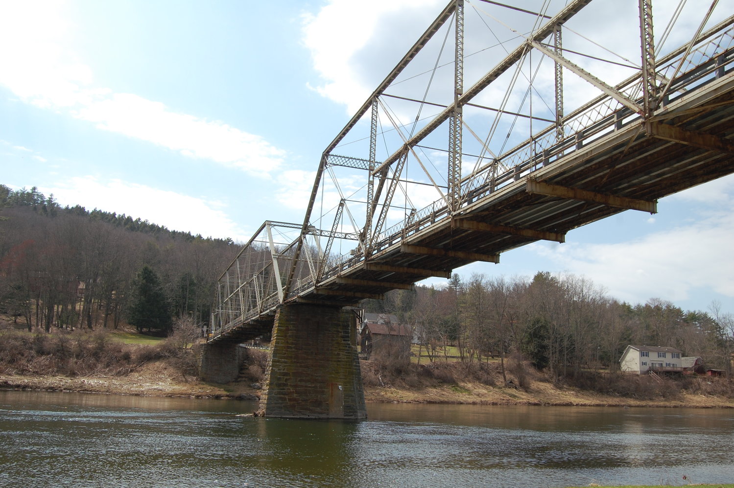 The Skinners Falls Bridge, with its Baltimore truss structure and single-lane wooden plank deck, as shown here, was constructed in 1902.