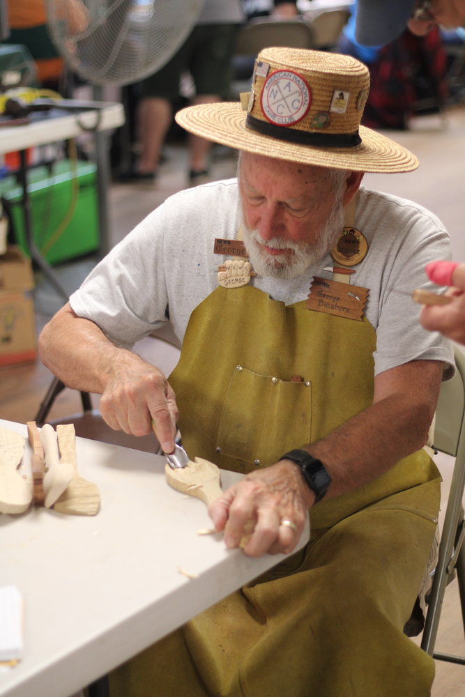George Basehore helps a student with carving.
