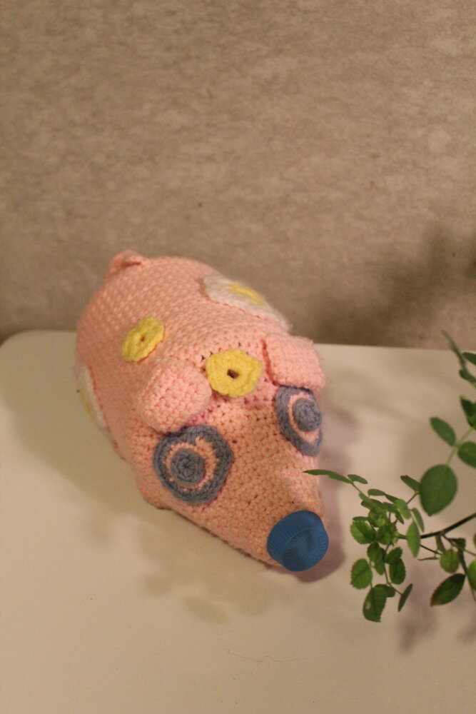Craft fairs can be a source of interesting and fun gifts too. This pig—actually a bleach bottle covered with a hand-crocheted skin and decorated with flowers—might be a bank. Lift its forehead flower and you'll find a hole into which you can put coins or other small objects. And then you unscrew the nose and shake out the treasure. ..